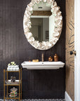 Handmade black and white patterned cement tile . Tile is on floor in bathroom with black cement blank on the wall.